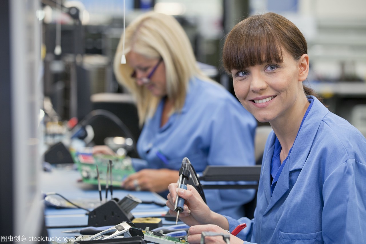 高科技电子制造工厂装配线上微笑技术人员的画像